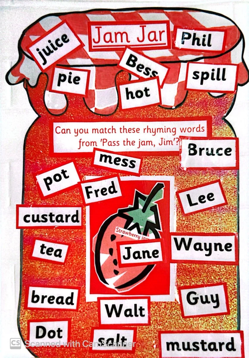 A classroom display cut out like a jam jar with printed word cards for a rhyming activity.
