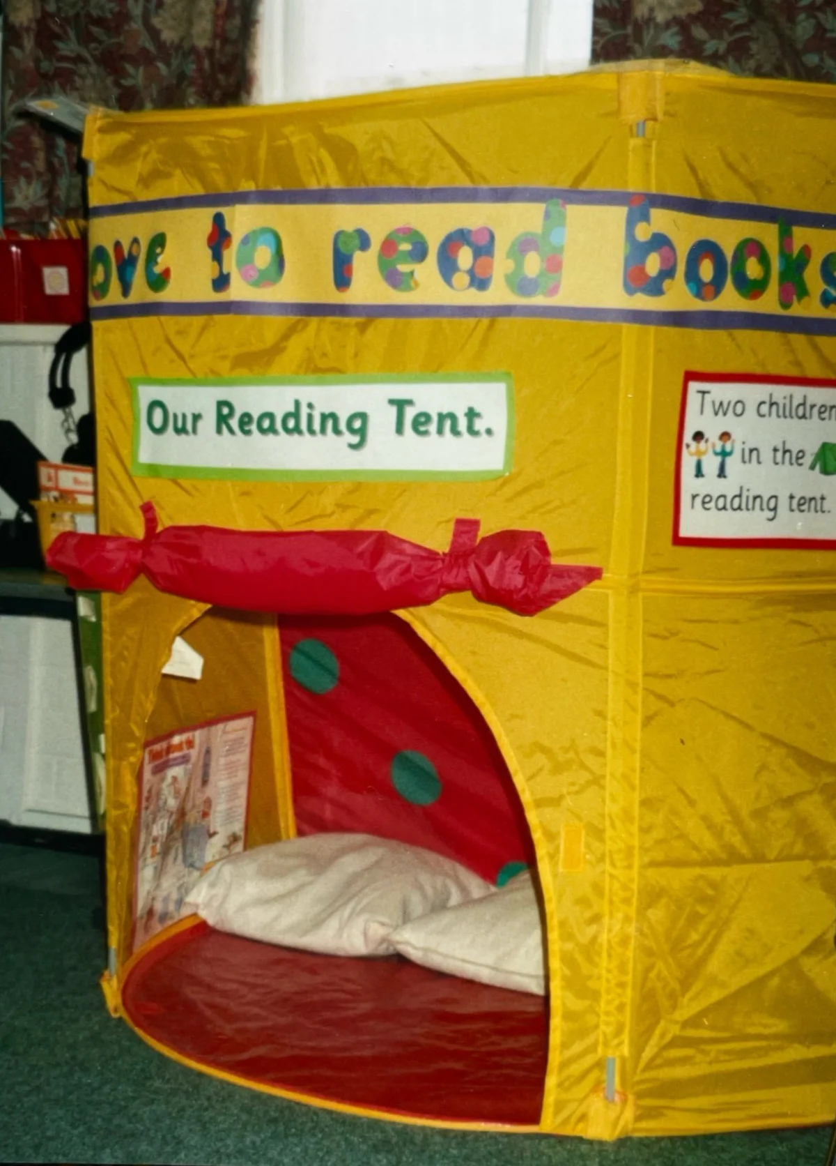 A bright yellow IKEA pop-up reading tent in a classroom, labelled Our Reading Tent with cushions inside.